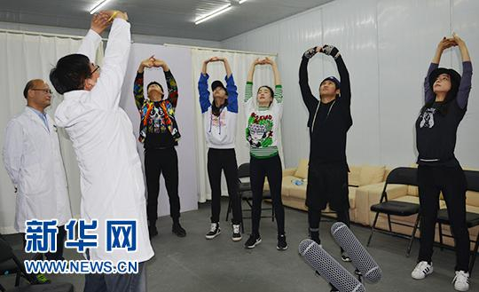 　　首都医科大学附属北京中医医院推拿科主治医师程五中（左二）教张静初（右一）等演员练习八段锦。新华网发 陶欢摄