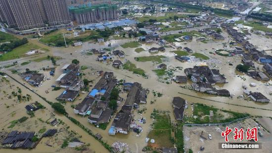 　　7月4日，因连续强降雨和长时间高水位浸泡，长沙浏阳河竹沙桥泵站出现一处险情，河水倒溢。长沙市水务局建设管理处最新透露，截至下午1时，浏阳河竹沙桥泵站险情基本得到控制，出险处水量减少。图为河水倒溢流入河岸边的村庄与道路。 摄影|中新 杨华峰