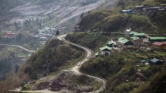 汽车在中印边境乃堆拉山口的盘山公路上行驶。