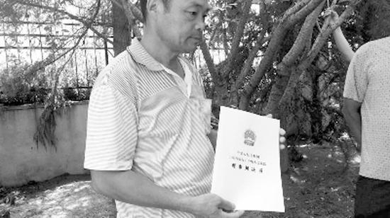 徐父手握判决书。