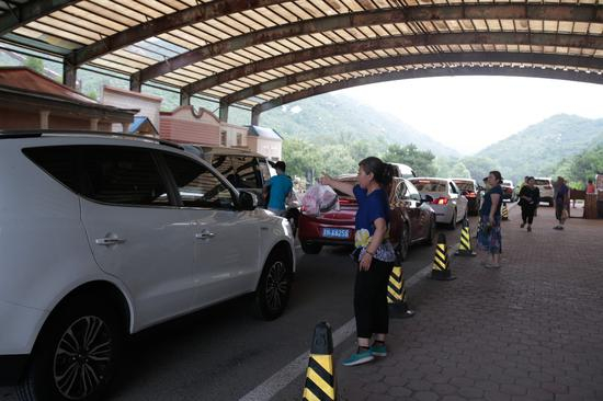 　　▲2017年7月15日，正值周末和暑假，来自驾游的游客络绎不绝，车辆在检票口排起长队，附近的商贩在向司机兜售动物食品。