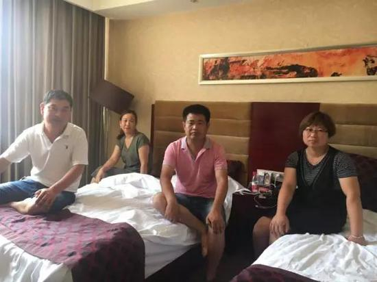两个被指控的老师邵俊立（左三）、何建设（左一）和家人躲在宾馆里。&nbsp;
