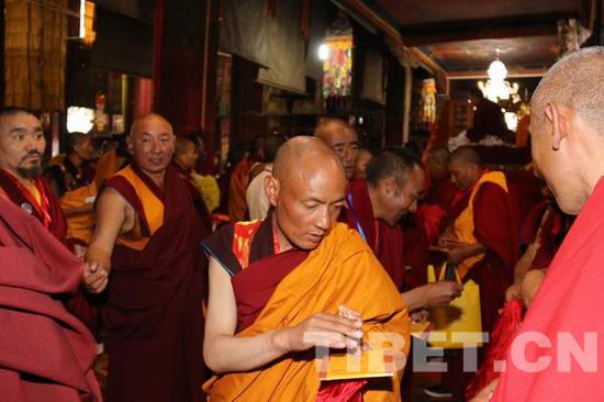 △图为拿到班禅大师赐物的僧人。