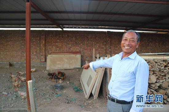 6月27日，村民白挨喜向记者展示自家饲养的鸡。新华网发 （赵冰摄）