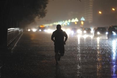 8月11日傍晚，一场急雨降临，一位市民在雨中奔跑。图/视觉中国