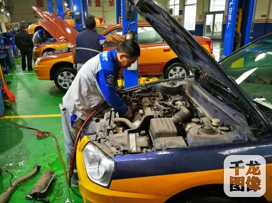 北京5万余辆出租车更换尾气“滤嘴”。图为师傅为出租车更换三元催化器。市交通委运输管理局供图 千龙网发