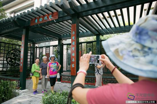 　　9月14日，市民在整治过后的北京市西城区椿树街道东椿树胡同清风亭合影（图片来源：tuku.qianlong.com）。千龙网记者 万小军摄
