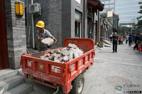 　　9月14日，施工人员在北京市西城区广内街道达智桥胡同内搬运碎石砖块（图片来源：tuku.qianlong.com）。千龙网记者 万小军摄