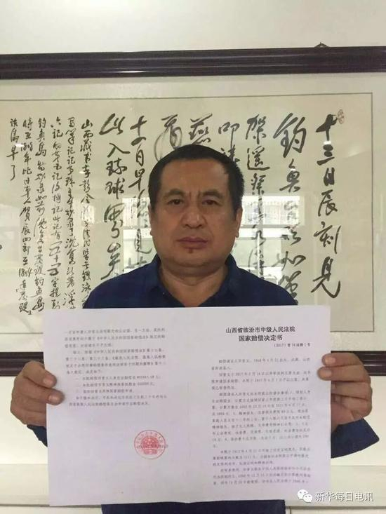 田晋文向记者展示国家赔偿决定书。