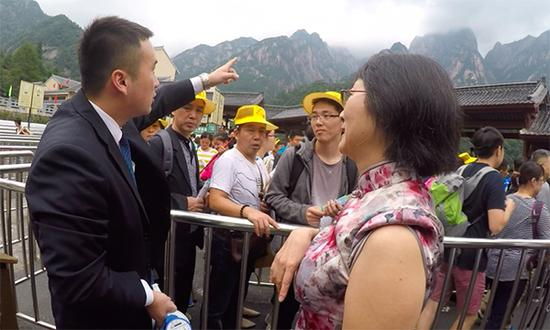 张仕庆耐心解答游客的疑问。澎湃新闻记者 胡芮默 图