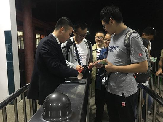 10月2日凌晨5：23，张仕庆在检票口为当天第一批赶上山的游客检票。澎湃新闻记者 胡芮默 图