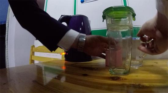 &nbsp;打开电水壶后，张仕庆准备去帮同事冲洗摆在桌上的水杯。澎湃新闻记者 胡芮默 图