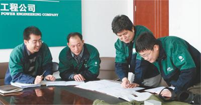 张文新（右二）与职工创新工作室成员讨论电缆技术攻关。李燕楠摄