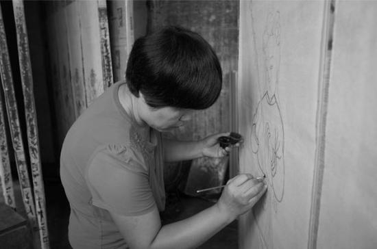 山东高密，王树花正在绘制扑灰年画。受访者供图