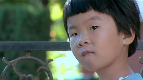 辰辰独自站在幼儿园门口等待南德。