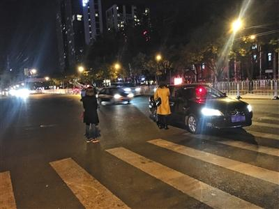 11月2日，北京工体北门，一名黑车司机和乘客商讨价格。如果遇到代驾的活儿，黑车司机则可“变身”代驾司机。