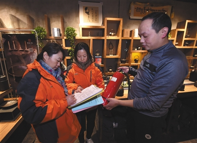 11月19日，朝阳区高碑店村村委会工作人员检查辖区内一家商铺的消防设施。 新华社记者 罗晓光 摄