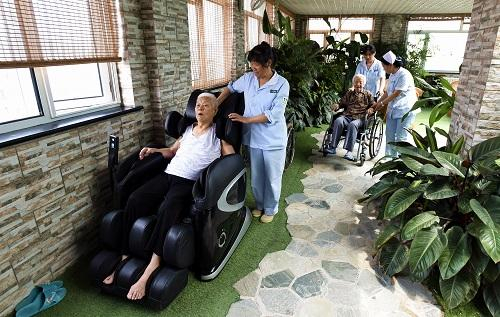 　　资料图片：2016年5月31日，老人在八里庄老年养护院的休闲空间赏花和接受按摩。新华社记者 李欣 摄