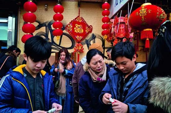 　　第二代第三代移民的生活方式已经越来越接近美国人，但很难说清究竟是谁影响谁更多一些。墙上的涂鸦和传统的灯笼融合在一起，人们低头查看着自己一年的运势。