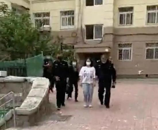 ▲ 　　此前网上流传的一段视频显示，警方曾将一名身穿白色上衣的女孩从张某所在小区单元楼带走