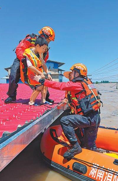 7月6日，湖南省湘潭市消防救援支队舟艇编队再次进入华容县团东村进行搜救工作，成功转移被困群众。许 琦摄（人民视觉）