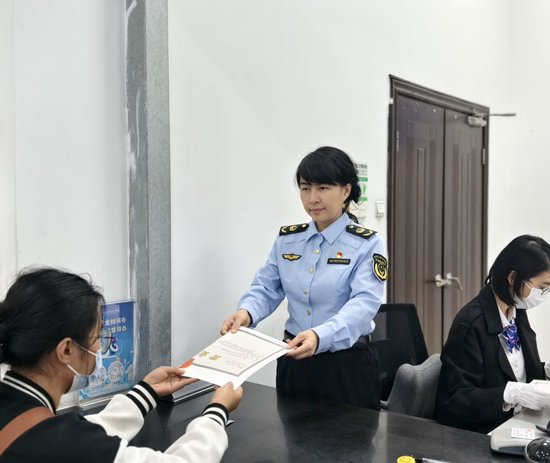 2026年2月6日，广州白云区市场监管局副局长孔丽雅（中）在帮助市民办理营业执照。（受访者供图）