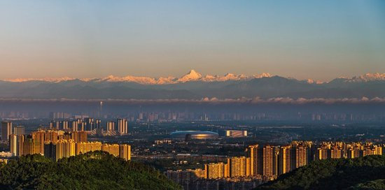 这是2021年6月4日清晨拍摄的成都市建筑群与远处的雪山。新华社发（嘉楠 摄）