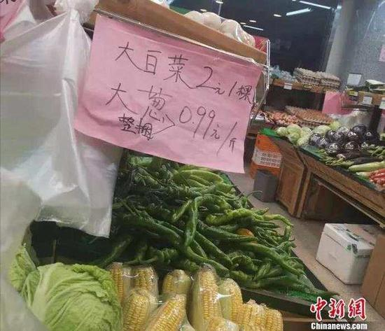 图为北京丰台一家社区超市正在促销大白菜和大葱。　谢艺观　摄