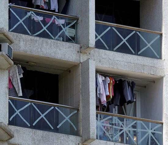 　　△15日，香港，随着台风“山竹”逼近，当地民众纷纷在建筑和车辆的玻璃上贴满胶带，防止玻璃碎裂伤人。（图自视觉中国）