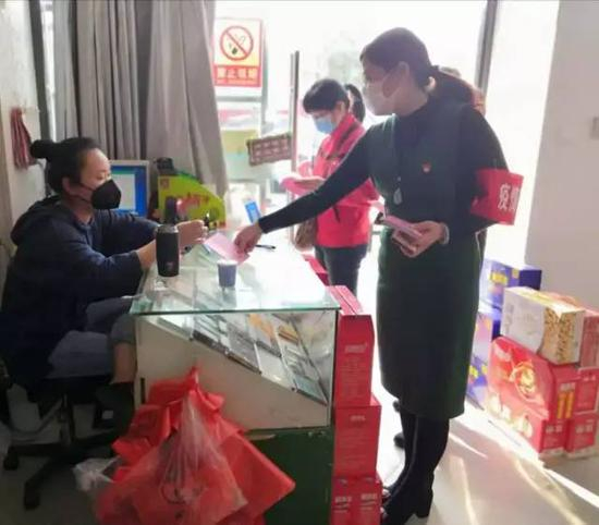▲董艳（右一）为商户发放疫情防控宣传材料&nbsp;