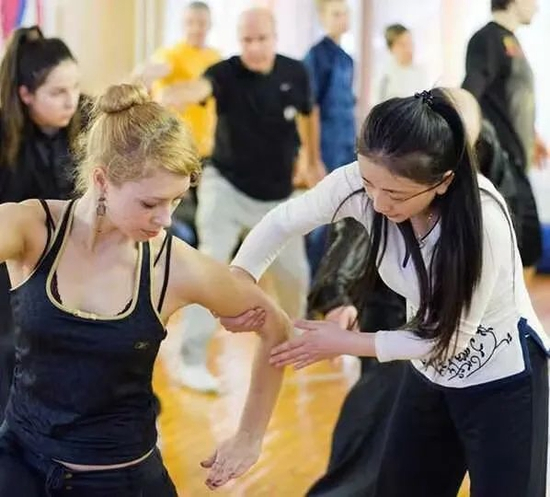 　·张含亮正在教外国学员学习武术。