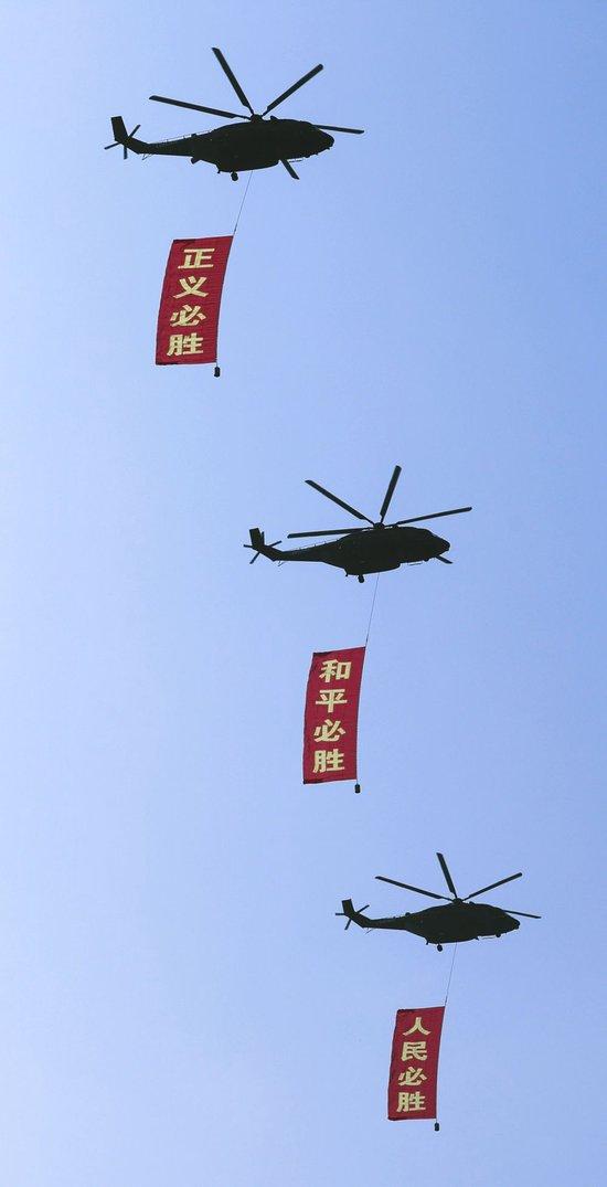 2025年9月3日，纪念中国人民抗日战争暨世界反法西斯战争胜利80周年大会在北京隆重举行。这是空中护旗梯队通过天安门广场，3架直-8L运输直升机分别悬挂“正义必胜”“和平必胜”“人民必胜”条幅。新华社记者 李钢 摄
