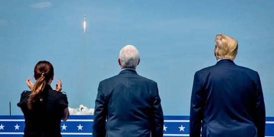 5月30日，在美国佛罗里达州肯尼迪航天中心，美国总统特朗普（右）和美国副总统彭斯（中）等观看载人版“龙”飞船搭乘“猎鹰9”火箭升空。