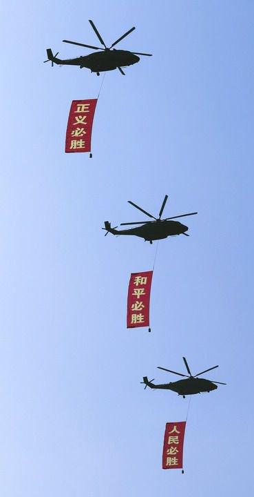 2025年9月3日，纪念中国人民抗日战争暨世界反法西斯战争胜利80周年大会在北京隆重举行。这是空中护旗梯队通过天安门广场，3架直-8L运输直升机分别悬挂“正义必胜”“和平必胜”“人民必胜”条幅。新华社记者 李钢 摄