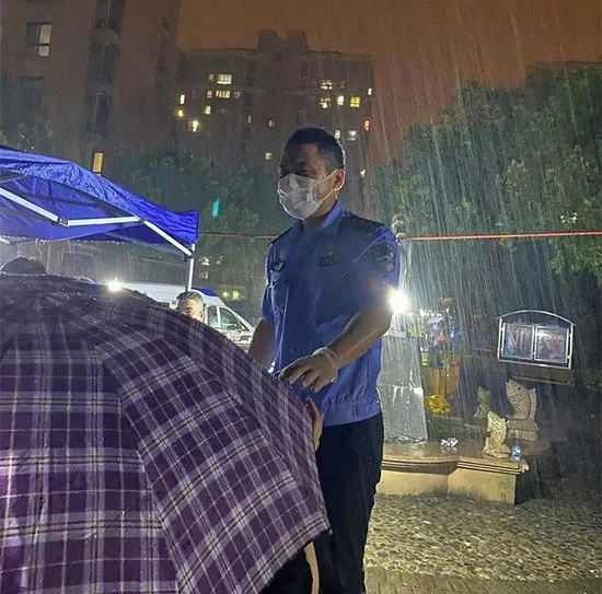  暴雨中维持核酸检测现场秩序的张伟峰。