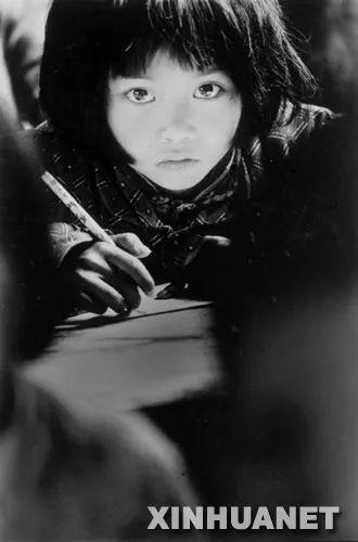  （图为1991年4月由谢海龙在安徽省金寨县桃岭乡三合中心学校拍摄的小学生苏明娟在认真听课的照片，这张著名的照片几乎成为“希望工程”的标志。）