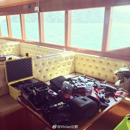 一层客舱图片，乘客围坐在桌子边。窗户不大。 资料图