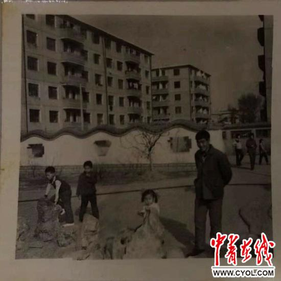 幼时的马小梅（右二）和父亲在楼下玩耍。