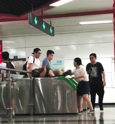 翻 两男子用双手撑住地铁检票闸机两侧，纵身翻过闸机口。视频截图