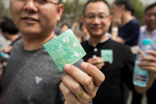 市民向记者展示雄安市民服务中心入口发放的“雄安好市民”绿色贴纸。王永康摄