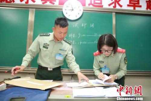 资料图：2018年全军面向社会公开招录文职人员考试。图为开考前监考人员检查试卷。　钟欣 摄
