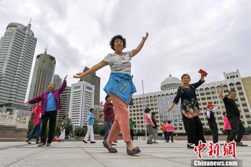 7月5日清晨，新疆乌鲁木齐，民众在人民广场上跳舞运动，锻炼身体。中新社记者 刘新 摄