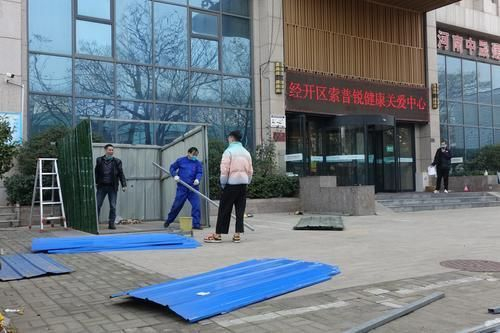 经南二路与经开第五大街交叉口附近，工人正在拆除因疫情防控而设立的隔离铁皮。
