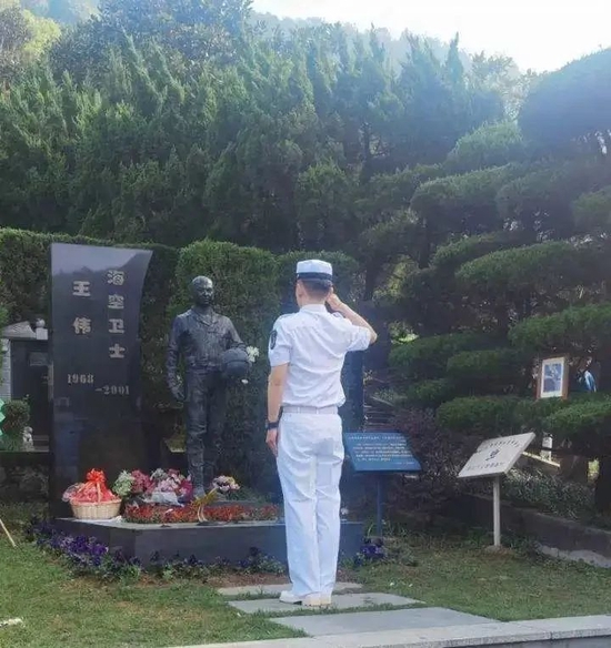 2021年3月28日，一位年轻人穿着海军军装，在王伟烈士墓前敬了一个标准军礼。