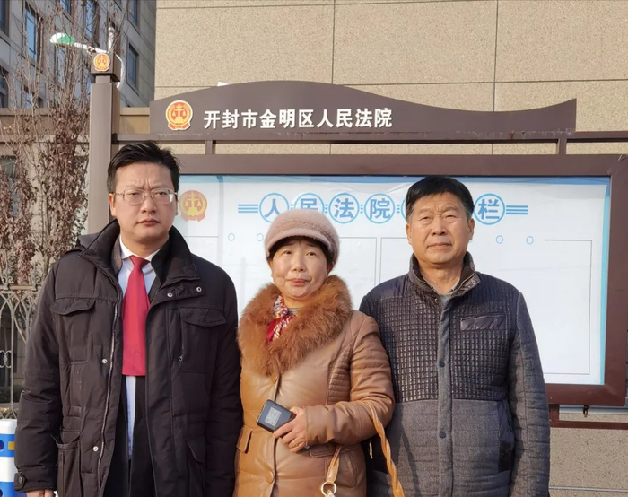 姚策的生父生母（右一、右二）及姚策的代理律师周兆成（左一）在法院外合影。受访者供图