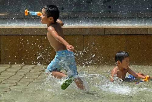▲资料图片：2017年7月20日，在日本东京一个公园，孩子们在喷泉池里玩耍。 （新华社/法新社）