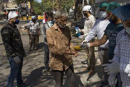 印度新德里，志愿者向民众分发食物。