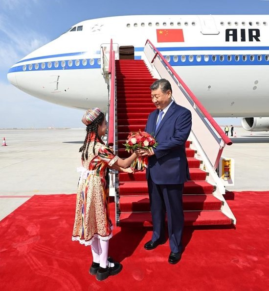 △2025年9月23日，习近平总书记率中央代表团乘专机抵达乌鲁木齐，出席新疆维吾尔自治区成立70周年庆祝活动。这是少先队员向总书记献花。