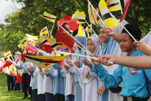 手持中文两国国旗的文莱青少年欢迎习近平主席访问文莱。人民日报记者 王芳摄