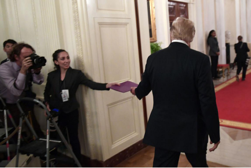 2018年9月12日，美国总统特朗普参加完在白宫举办的招待会离开时，《大纪元时报》摄影记者违反安保规定，在禁区内向特朗普塞了一个文件夹